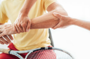 orthopedic doctor examine the elbow pain of tennis player