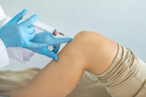 Doctor doing PRP therapy on a patient's knee