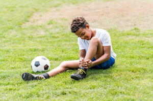 soccer player outdoor in sunny day having ankle injury